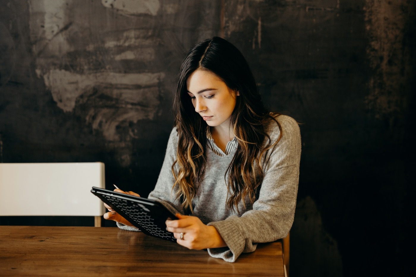 Restaurant owner checking reports on a tablet at a wooden table